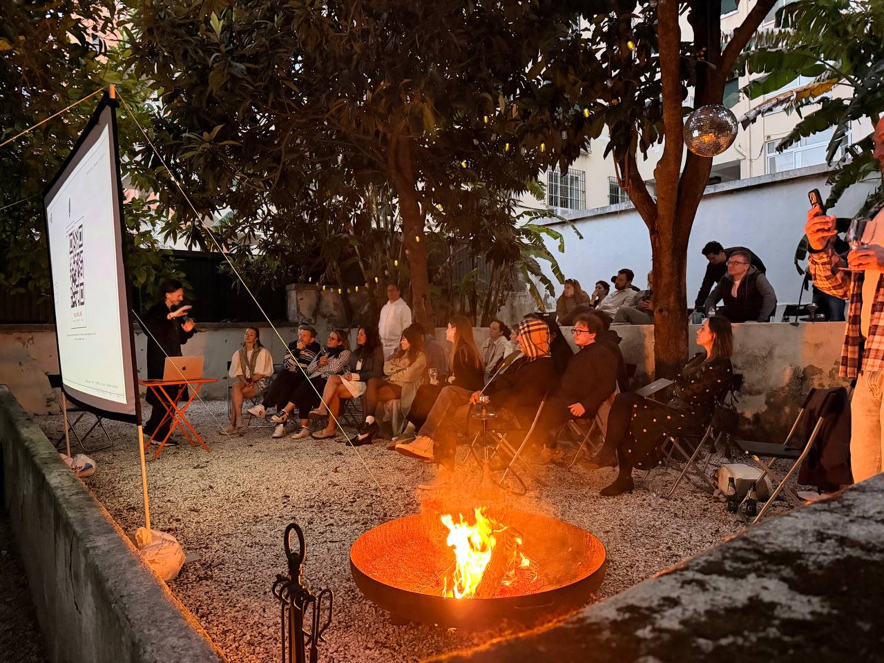 Founders gathered around a fire pit in a Lisbon garden at dusk